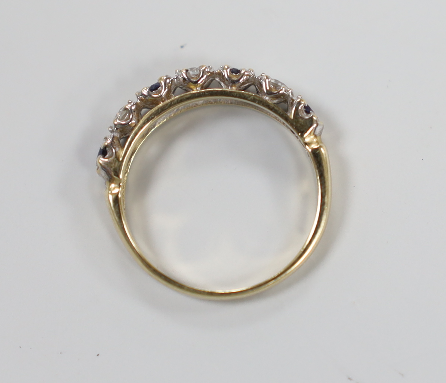 A modern 14ct gold and two colour sapphire? set half hoop ring, size K/L, gross weight 2.3 grams.